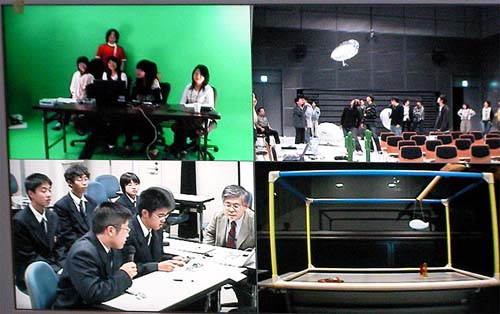 図4:マジカルワークショップの様子(2008.10.21実施) 写真は、熊本(左下)からのスプーン指令により、東京(右上)の飛行船が操作されている様子。空間モデル(右下)を使って、飛行船の現在位置を提示中。札幌(左上)は次の作戦会議中。