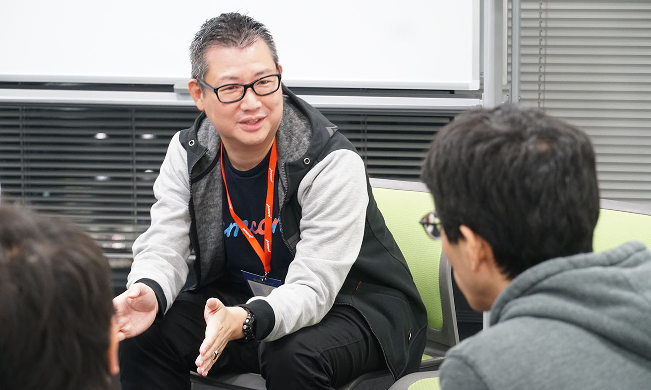 車座で聴講者の質問に答える山崎氏
